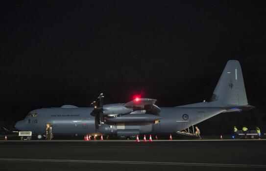 A C-130J aircraft on the flight line at night