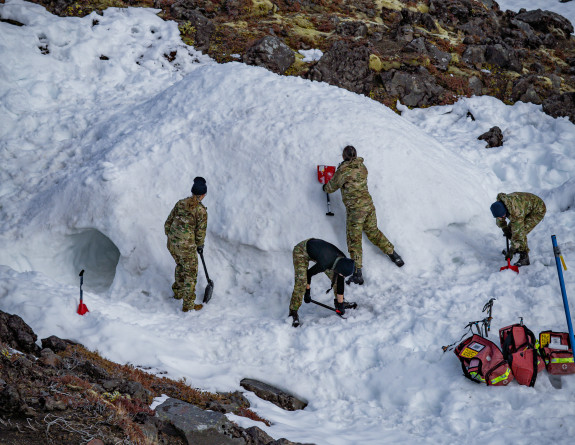 NZDF personnel make a shelter as part of a five-day cold weather survival course on Mt Ruapehu. Bird's eye view image looking down on the personnel making shelter out of the snow. 