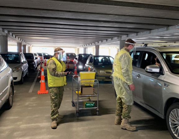 NZ Army medics in protective equipment vaccinate people in their vehicles in the Wellington's Sky Stadium carpark.