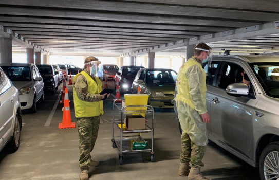 NZ Army medics in protective equipment vaccinate people in their vehicles in the Wellington's Sky Stadium carpark.