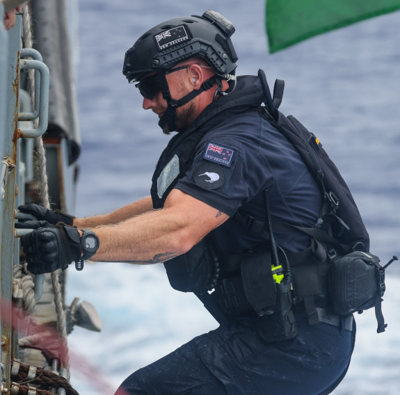 A sailor climbs up a ladder aboard HMS Tamar