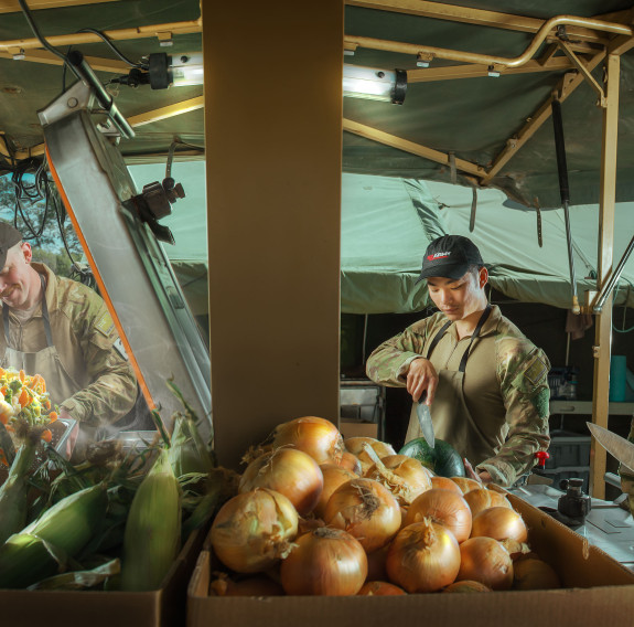 Army personnel working in a temporary kitchen in the field