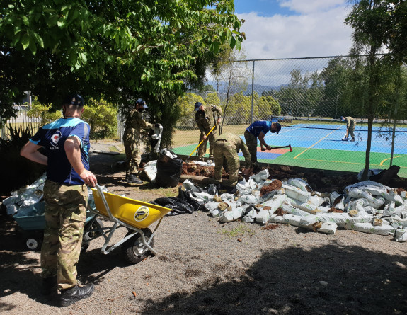 The officer cadets with wheelbarrows and helping in the garden on a sunny day