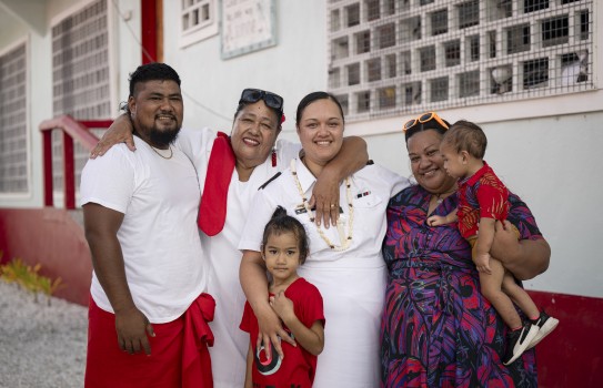 Six people standing looking at the camera with their arms around each other.