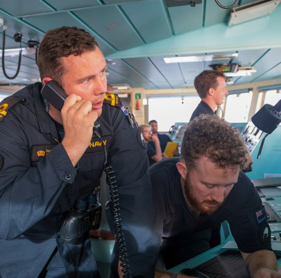 Two sailors looking away from the camera on the bridge of HMS Tamar