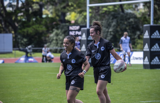 Two players for the NZDF team are all smiles during practice on the field.