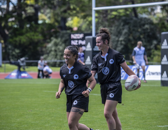 Two players for the NZDF team are all smiles during practice on the field.