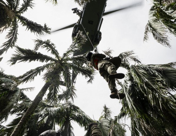 A member of the contingent is winched up to a waiting RNZAF NH90 helicopter