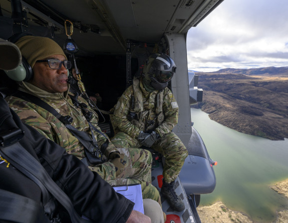 Personnel in uniform look out an NH90 helicopter.