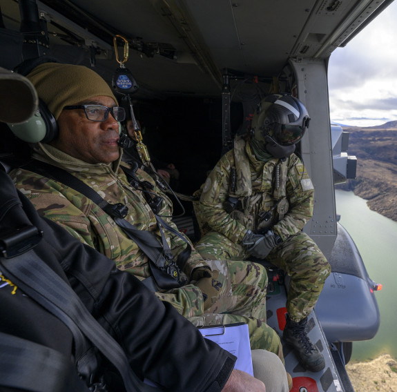 Personnel in uniform look out an NH90 helicopter. 