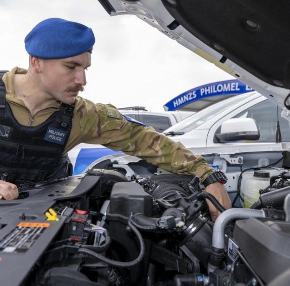 A member of the Military Police inspect the engine of one of the new vehicles.