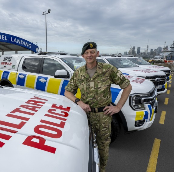 A soldier leans on the bonnet of one of the new vehicles which has the words "Military Police" on the front.
