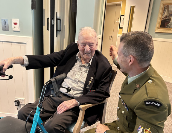 Sergeant Major of the Army Warrant Officer Class One Dave Alder (right) talks with Mr Doug Reid who is sitting in a chair.