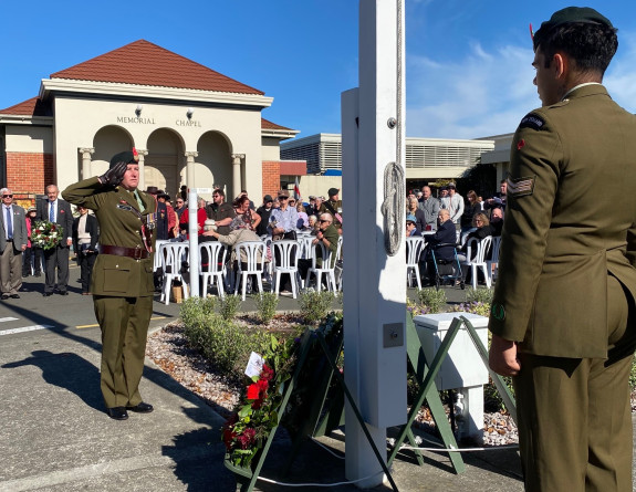 Major Buffy Little salutes after laying a wreath