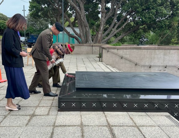 People pay their respects by placing a hand on the tomb of the unknown warrior.