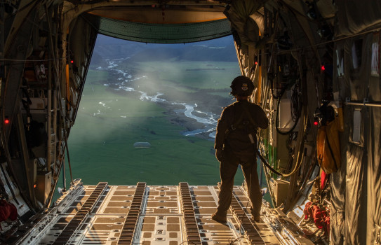 A loadmaster watches the drop after it successfully leaves the aircraft