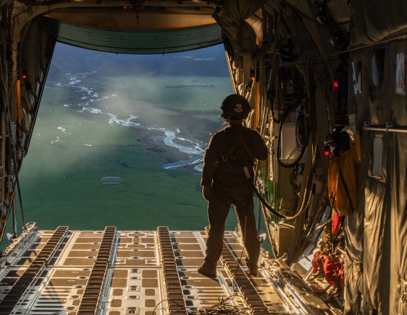 A loadmaster watches the drop after it successfully leaves the aircraft