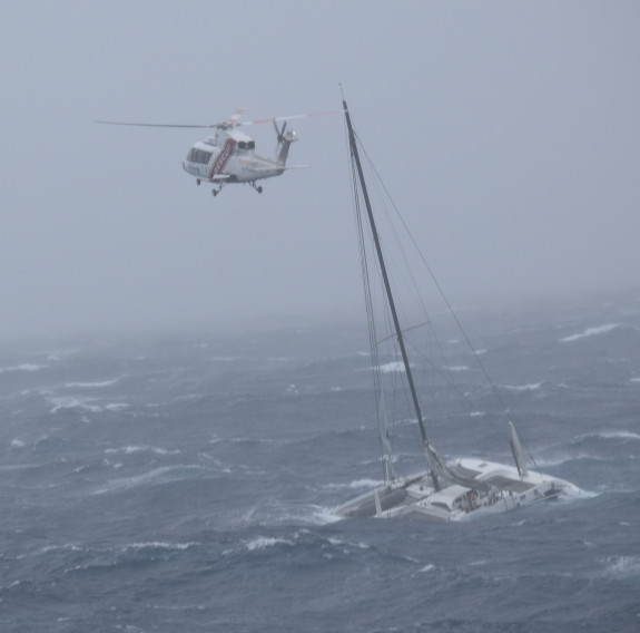 A rescue helicopter flies low over a yacht in the poor weather conditions caused by Cyclone Gabrielle. 