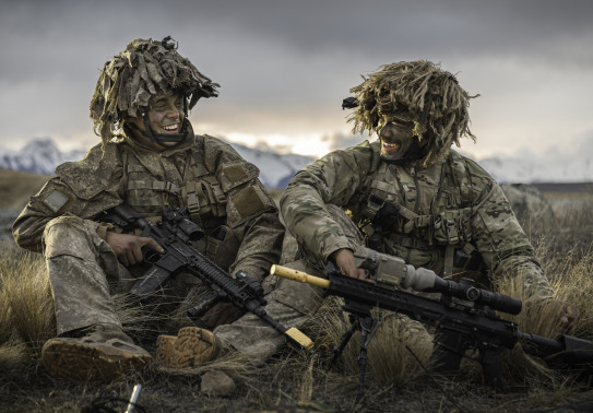 Two soldiers smiling at each other while sitting down in the Waiouru Military Training Area