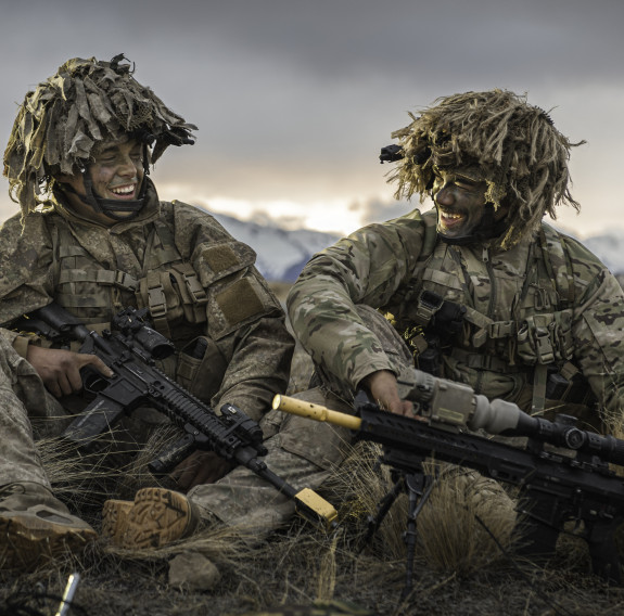 Two soldiers smiling at each other while sitting down in the Waiouru Military Training Area